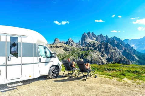 Family relaxing in camping chairs, enjoying breathtaking view of tre cime di lavaredo, dolomites,