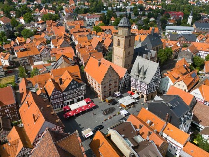 Bird's eye view of the lively market square of a historic town with half-timbered houses and a