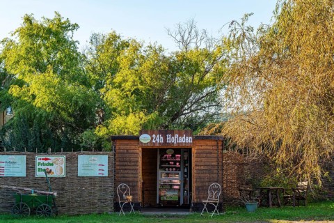 Wooden hut with a vending machine for sausage and cheese in a 24-hour farm shop, village of Rieben