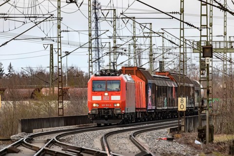 Goods train travelling on the winding Schuster Railway, overhead lines and infrastructure.