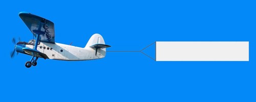 biplane with a banner in the sky