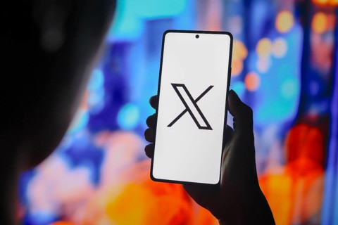 In this photo illustration, the X (Twitter) logo is displayed on a smartphone screen