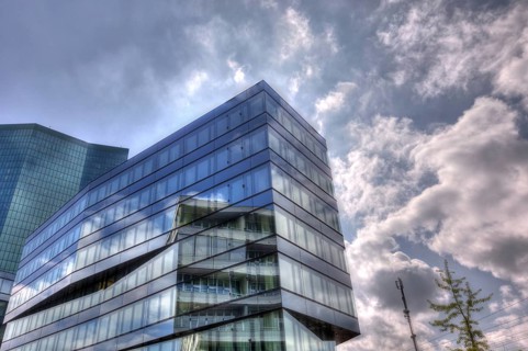 Modern building with glass facade in front of a cloudy sky and reflecting light, Prime Tower