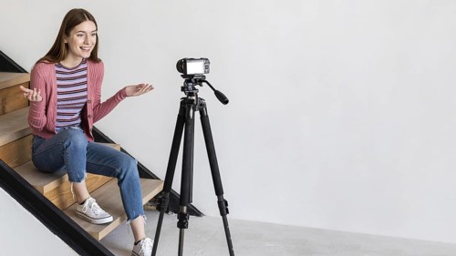 Blogger recording with camera sitting stairs. Resolution and high quality beautiful photo