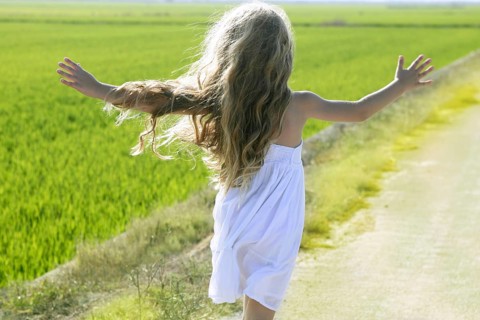 Rear view running open arms little happy girl green meadow field track