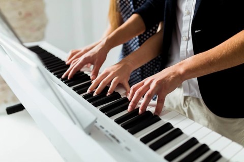 Close up couple s hand playing piano keyboard