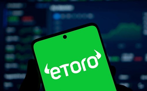 etoro logo is displayed on smartphone. eToro is a social trading and multi-asset investment company
