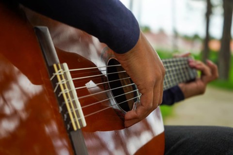 Playing Guitar in Green Park. Guitar Body. Close-Up Shot