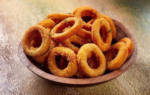 Deep fried onion rings, appetizer, with tomato sauce, on a wooden plate, without people, favorite