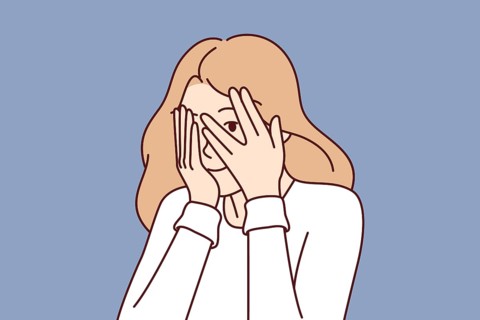 Woman covers eyes with hands and peeps, refusing to see unpleasant things and hiding from problems.