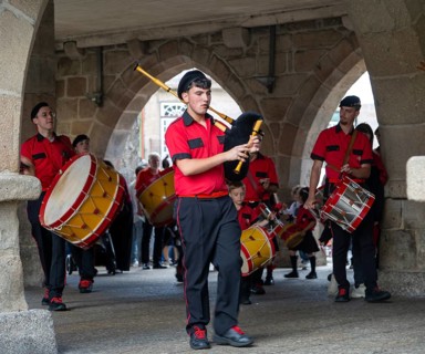 Traditional drum and pipe band perform on city streets on May Day 2025, Guimaraes, Braga district,