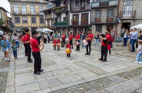 Traditional drum and pipe band perform on city streets on May Day 2025, Guimaraes, Braga district,