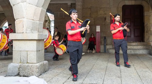 Traditional drum and pipe band perform on city streets on May Day 2025, Guimaraes, Braga district,