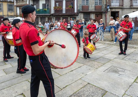 Traditional drum and pipe band perform on city streets on May Day 2025, Guimaraes, Braga district,