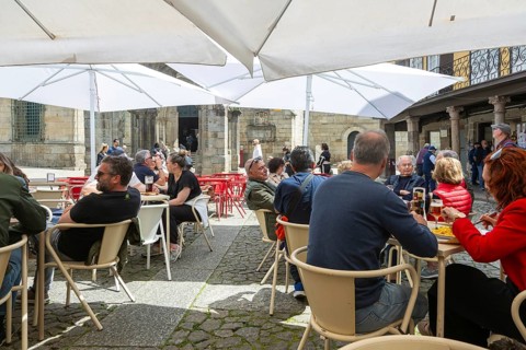 Customers sittimg outside at cafe tables, Largo da Oliveira square, city of Guimaraes, northern