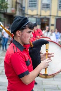 Traditional piper in band performing on city streets on May Day 2025, Guimaraes, Braga district,