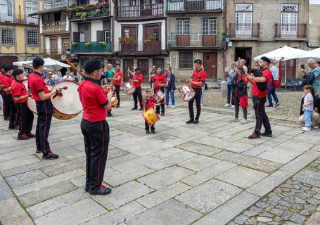 Traditional drum and pipe band perform on city streets on May Day 2025, Guimaraes, Braga district,