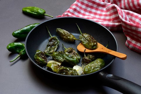 Pan-fried pimientos de padron in olive oil, roast peppers
