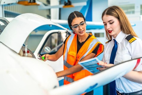Aircraft maintenance engineer and a pilot are performing a pre flight check, consulting a