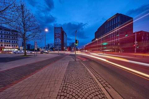General architecture, modern building, bare wintry trees, traffic lights, pavement made of paving