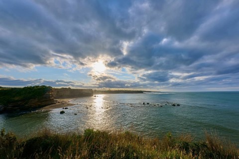 Sunrise over calm sea, dramatic clouds and light reflections, Opunake, Taranaki, North Island, New