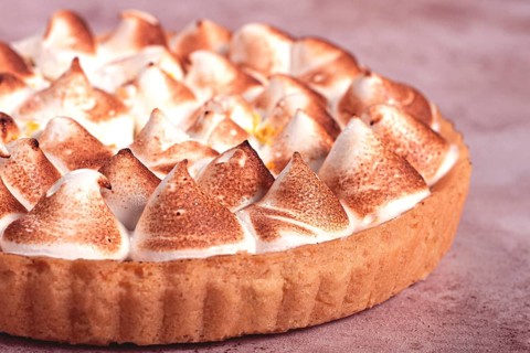 Lemon meringue cake, golden brown, toasted, on a light table, no people