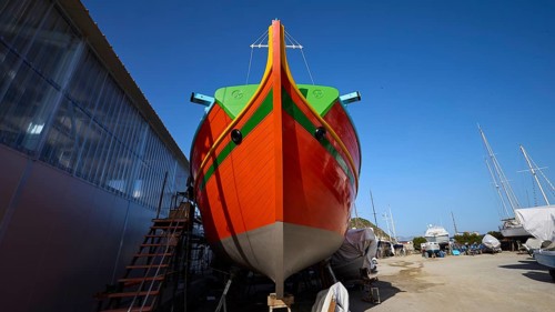 Large orange boat in a shipyard in front of a blue sky, boatyard Diakofti, new construction of a