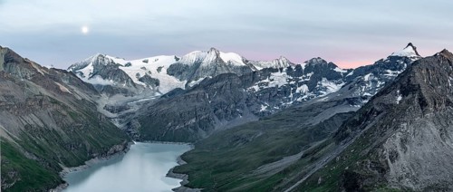 Mountain landscape with turquoise blue reservoir Lac des Dix and summit Mont Blanc de Cheilon, moon