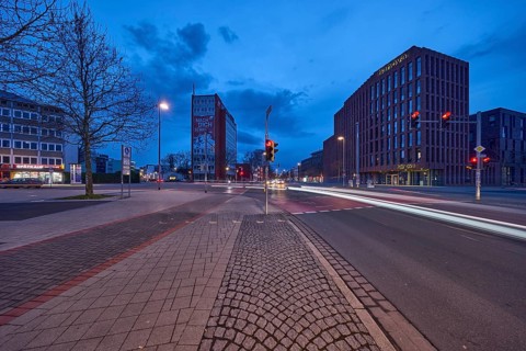 General architecture, modern building, bare wintry trees, traffic lights, pavement made of paving