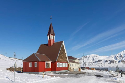 1958 red wooden Evangelical Lutheran Svalbard Church in the town Longyearbyen in winter,