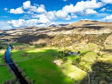 Farms and Mountains over River Dochart and Road A85 from a drone, Perthshire, Scotland, UK