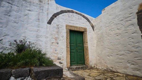 Green door in a courtyard with plants and whitewashed walls, Monastery of the Revelation, Moni tis