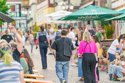 Street scene with people and policemen during a summer entertainment in the city, railway station