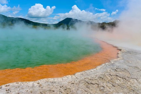 Bubbling mineral spring with steam and surrounded by mountains, Champagne Pool thermal lake,