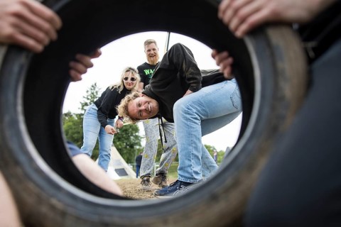 Festival visitors look through a car tyre on a campsite at the Rock am Ring Festival on Saturday,