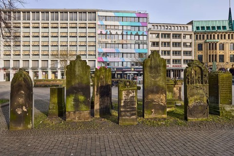 Historic gravestones, general architecture, diffuse light, pale blue cloudy sky, slightly sunny,