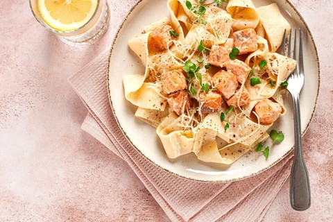 Tagliatelli pasta, with salmon slices and herbs, on a decorative plate, homemade, no people
