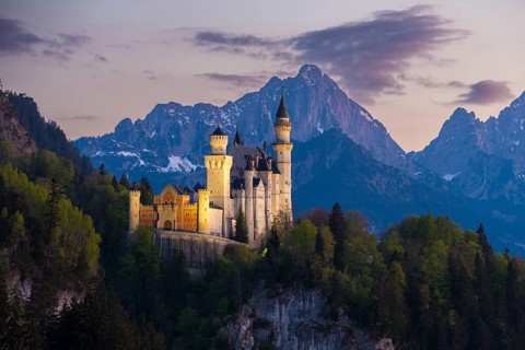 Fairytale castle against a mountain backdrop in the soft evening light, Neuschwanstein, Schwangau