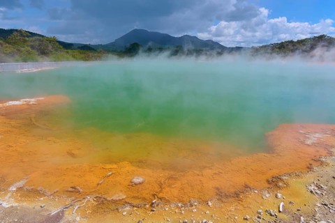 A geothermal area with steaming water and blue skies, Champagne Pool thermal lake, Wai-O-Tapu
