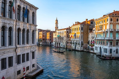 View of the Grand Canal with gondoliers at sunset, picturesque evening mood with palazzos on the