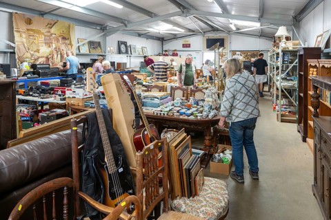 People at auction viewing inside auction room of household clearance lots, Suffolk, England, UK