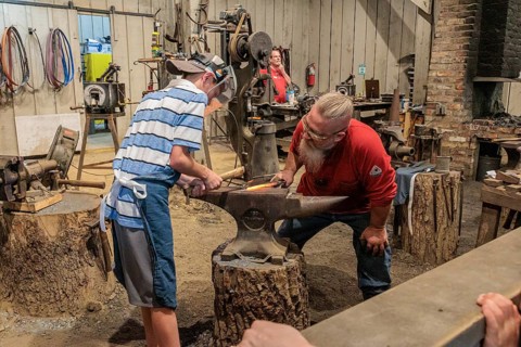 Park guest gets hands on experience at the Valley Forge Blacksmith demonstration at the Dollywood