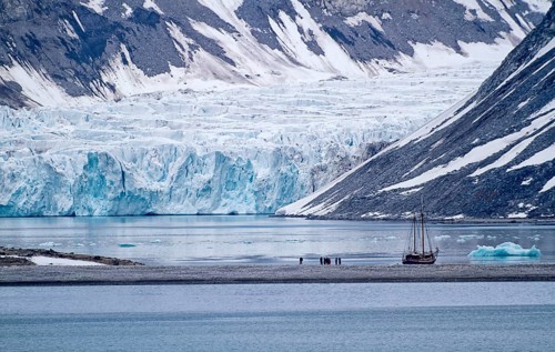 A sailboat in front of a glacier in a cold and calm arctic landscape, Magdalenenfjord with