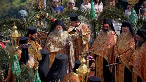 Orthodox priests in splendid robes hold a solemn ceremony with golden elements and palms, Orthodox