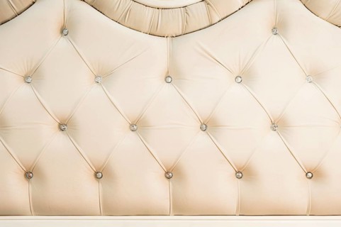 Beige soft textile background with symmetrical buttons on the corners of diamonds. Soft and