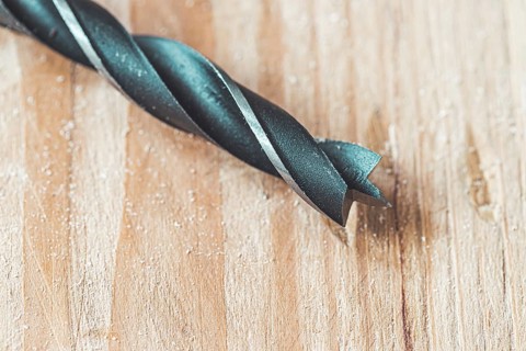 Close up of driller lying on wooden plank