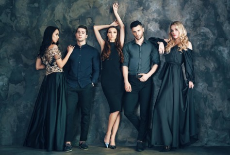 Group of young beautiful people posing in studio. Fashion photo concept