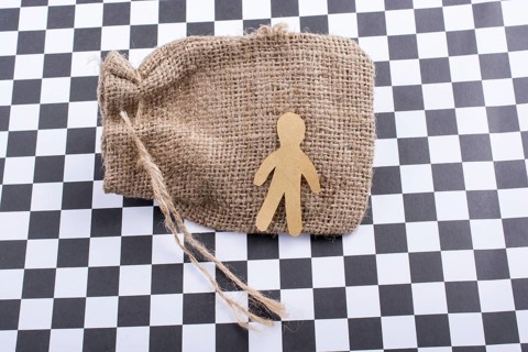 Man shape cut out of paper on canvas sack