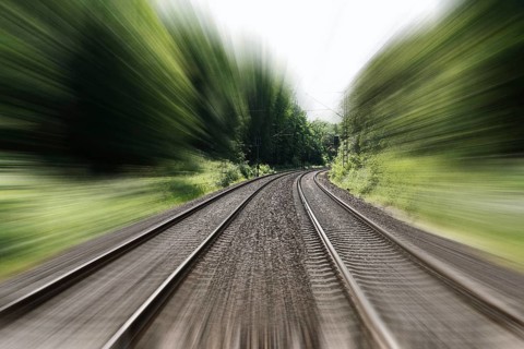 double-track railroad railway or train tracks with speed motion blur - fast travel concept