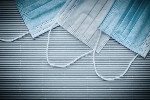 Medical disposable sterile masks on striped background top view